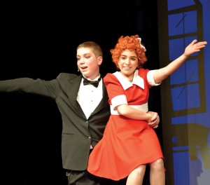 Cedar Rapids LaSalle Middle School sixth-graders Colin Battien and Samantha Robinson perform a musical number as Oliver Warbucks and Annie in “Annie, Jr.,” Dec. 4-5, 2014. (Contributed photo)